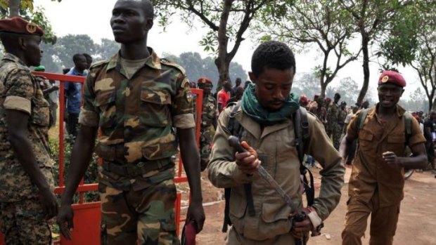 A soldier puts his knife away after allegedly taking part in the lynching of a man suspected of being a former Seleka rebel.