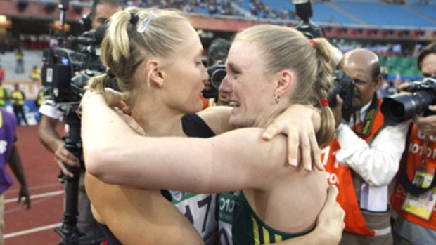 Training partners Andrea Miller (left) and Sally Pearson embrace after winning bronze and gold respectively in the 100m hurdles.