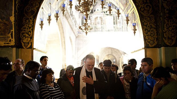 Some of the rescued Chilean miners pray at the Church of the Holy Sepulchre.
