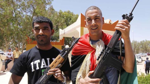 The game is up ... footballers Owsma Abdul Salam and Juma Gtat pose with rebel weapons in the city of Zintan.