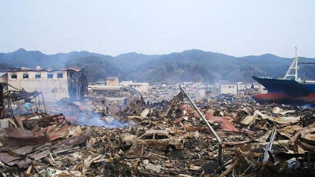 Total destruction ... debris and wrecked houses smoulder in Ofunato City after the tsunami.