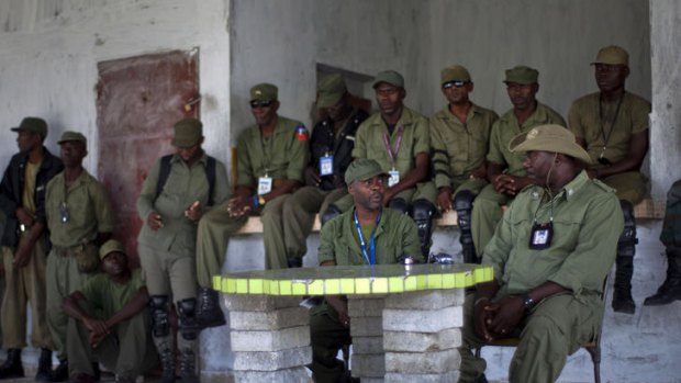 Members of the dissolved Haitian army gather before a press conference at an army barracks outside Port-au-Prince.