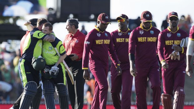 Down and out: The West Indies team leaves the field after being beaten by Ireland.