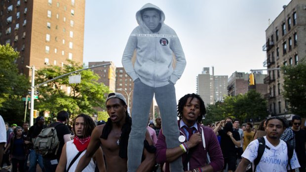 Protesters carry an image of the late Trayvon Martin through the Lower East Side of Manhattan in a rally against the Florida murder trial acquittal.
