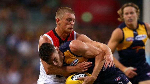 Hard contest: Sebastian Ross tackles Luke Shuey in Perth.