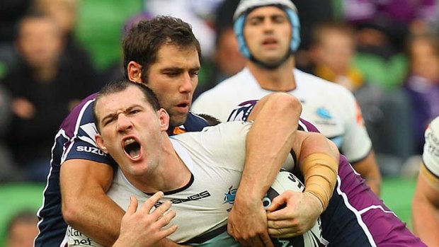 Shark netted: Storm captain Cameron Smith holds onto his Cronulla opposite number Paul Gallen at AAMI Park yesterday.