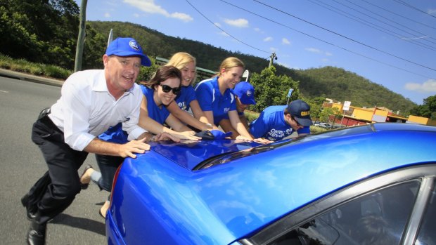 Campbell Newman helps a stranded driver in Ashgrove during the last state election campaign.