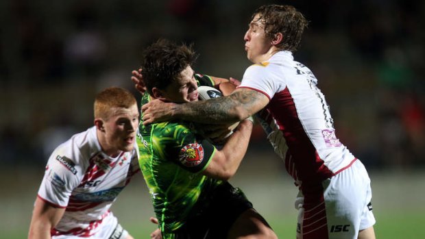 Got him: Warriors player Jarrod Wilson is tackled by Sam Powell of Wigan at Waikato Stadium on Wednesday night.