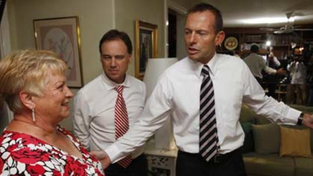 Spot fires...Tony Abbott visits Christine Mikolajczak, whose lounge room ceiling caught on fire after insulation was installed last year.