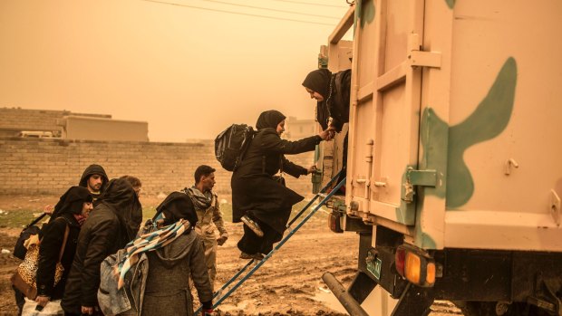 Civilians get into a military truck while trying to flee from Mosul under heavy shelling by Islamic State.