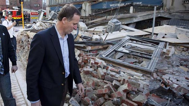 John Key surveys the damage shortly after a 7.1 magnitude earthquake last year, one of three major tremors in the past nine months.