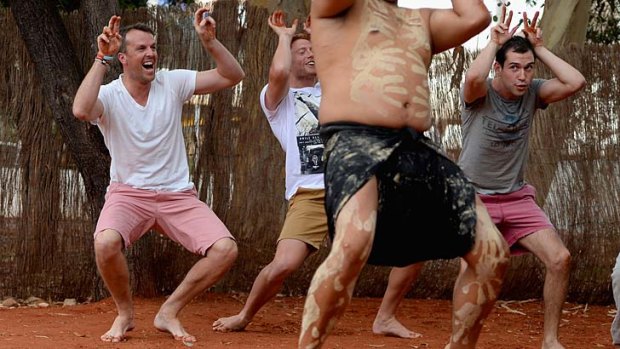 Graeme Swann, left, performs with Wakagetti cultural dancers during a team visit to Uluru.