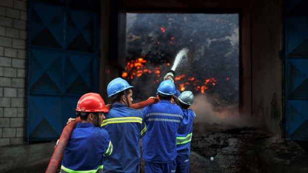 Firefighters attempt to extinguish a fire in a warehouse with sugar at the port of Santos, the biggest of Latin America, some 60 km of Sao Paulo, Brazil.