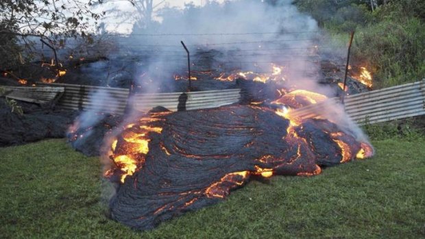 Slow-moving lava burns through a fence.