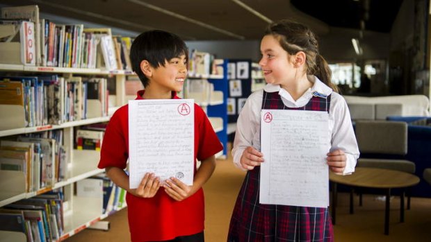 Year 4 students, Toby McCormack, from Chapman PS, and Keira Barrack from Harrison School hold their A graded work.
