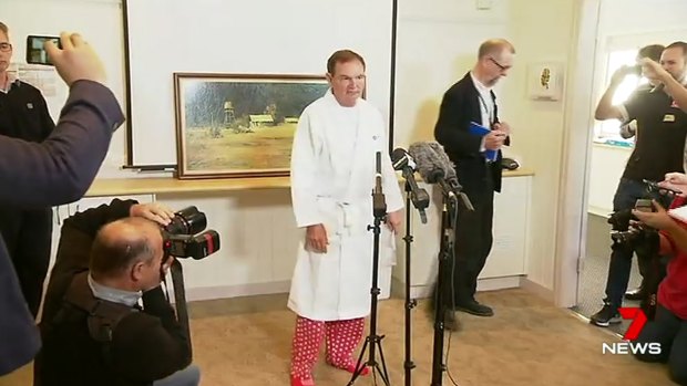 Ipswich mayor Paul Pisasale, wearing a hospital gown and pyjamas, announces his resignation.