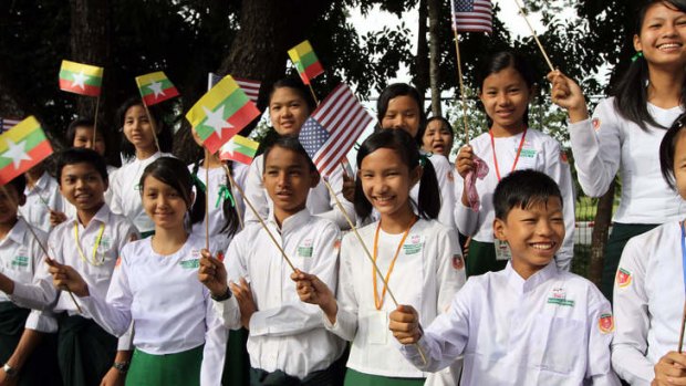 On the streets ... Burmese students wave flags as they welcome President Barack.