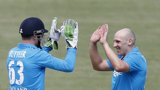 England's James Tredwell  is congratulated by wicketkeeper Jos Buttler after they combined to dismiss Scott Henry.