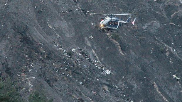 Helicopter flies over debris of a Germanwings passenger jet, near Seyne-les-Alpes, Frances.
