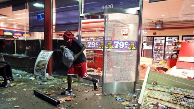 Looting ... A man leaves a store with a bag of goods after a protest turned into rioting in Ferguson, Missouri.