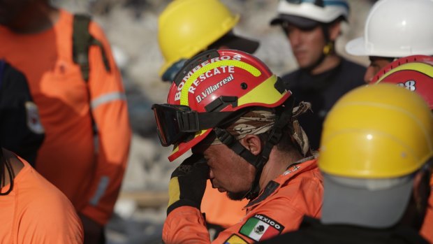 A weary rescue group work in the rubble in Pedernales, Ecuador on Tuesday.