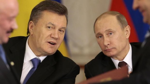 Economic relief for Ukraine ... Russian President Vladimir Putin, right, and his Ukrainian counterpart Viktor Yanukovych, left, react after signing an agreement in Moscow on Tuesday.