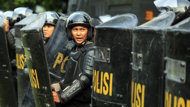 Indonesian police stand guard in front of the Elections Commission.