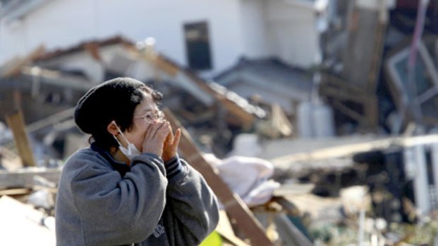 A woman calls for family as she searches ruins in Miyagi prefecture.