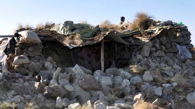 A handout photo from Pakistan's Inter Services Public Relations shows a Pakistani soldier walking behind a destroyed border post after the cross-border NATO air strike.