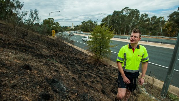 DHL Australia courier Andrew Reardon, of Dunlop, stopped to put out a fast-burning fire on Parkes Way on Wednesday at the base of Black Mountain.
