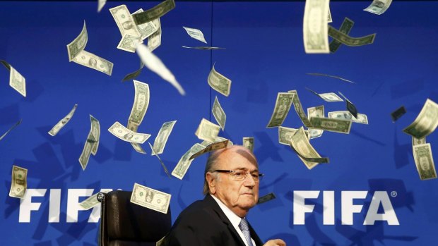 Looking uncomfortable ... British comedian known as Lee Nelson (unseen) throws banknotes at FIFA President Sepp Blatter as he arrives for a news conference at FIFA headquarters in Zurich.