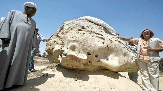 Archaeologist Hourig Sourouzian, who heads the project to conserve the Amenhotep III temple, stands next to a newly displayed alabaster head.