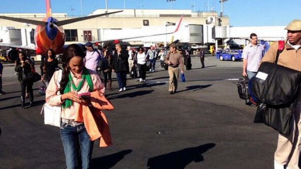 Airline passengers are evacuated to the tarmac at Los Angeles International Airport.