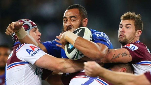 Sandwiched: Bulldogs prop Sam Kasiano is crunched by the Manly defence.