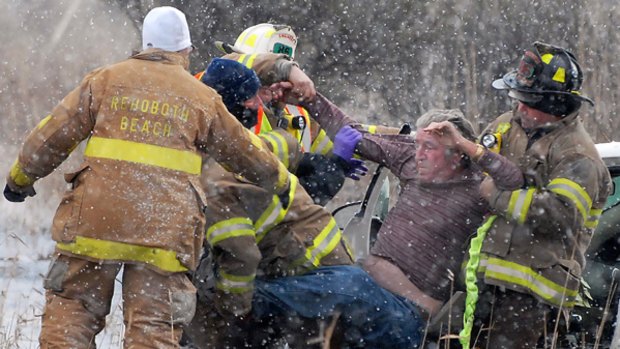 Firefighters rescue a driver beside an icy highway in Delaware.