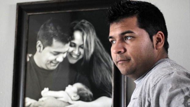 Won legal battle: Erick Munoz, in front of a family portrait with his wife and son.