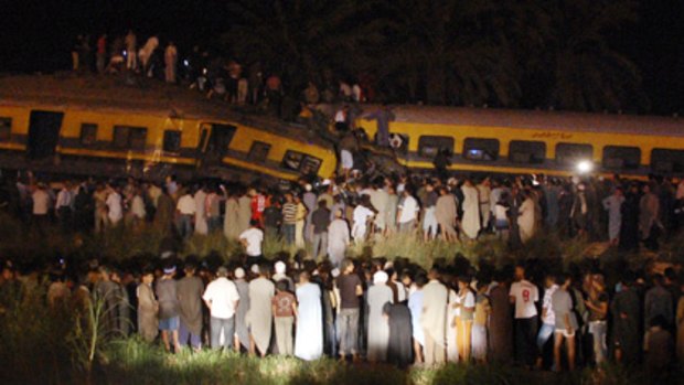 Egyptians gather around the site of a collision between two passenger trains in the Girzah district.