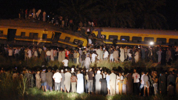 Egyptians gather around the site of a collision between two passenger trains in the Girzah district.