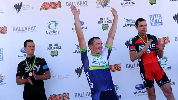Simon Gerrans celebrates his win on the podium while Cadel Evans (right - second) and Richie Porte (third) look on.