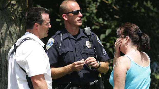 Members of the Akron police department talk to an unidentified woman who claimed to be a relative at the scene of the multiple shooting in Ohio.