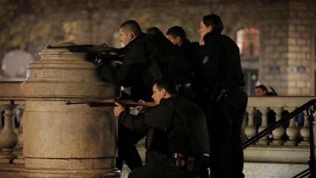 Police with weapons drawn react to suspicious behaviour at Place de la Republique in Paris.