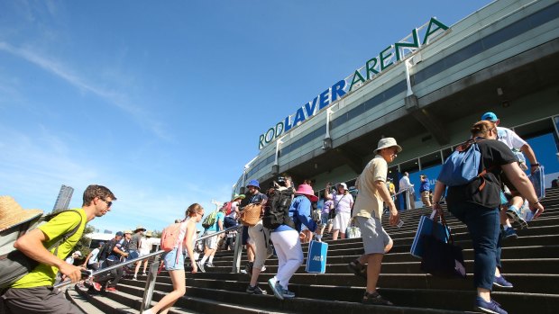 Tennis fans  rush into Rod Laver Arena on the first day of the Australian Open on Monday.