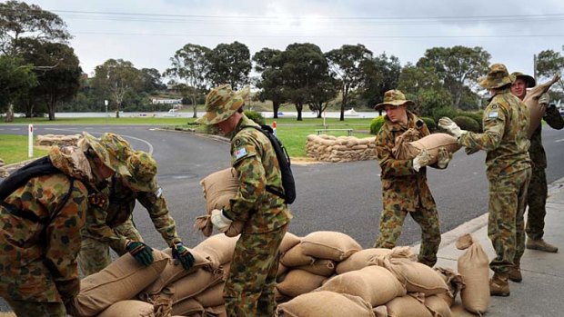 Soldiers lay sandbags in Barkes Ave, Lakes Entrance in preparation for the flood.
