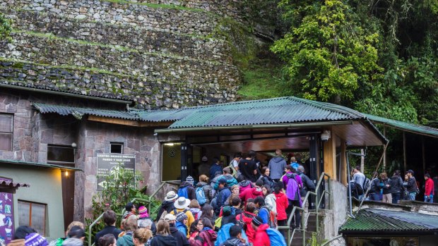 Crowds of tourists wait in long line at Machu Picchu.