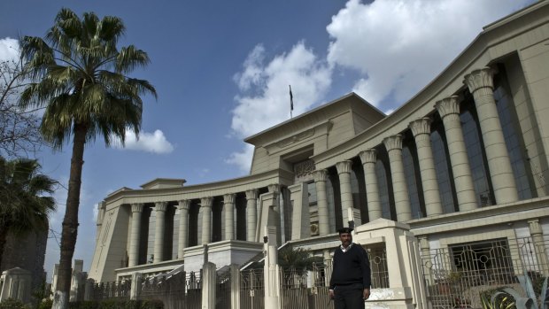 An Egyptian policeman stands guard outside the Supreme Constitutional Court in Cairo during a court session to determine if the House of Representatives parliamentary election law is constitutional. 
