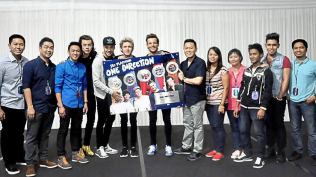 <i>One Direction</i>'s Liam Payne covers the face of former band member Zayn Malik at a photo call during the band's Asian tour.