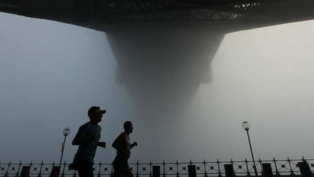 Sydney Harbour Bridge shrouded in fog on Sunday morning.