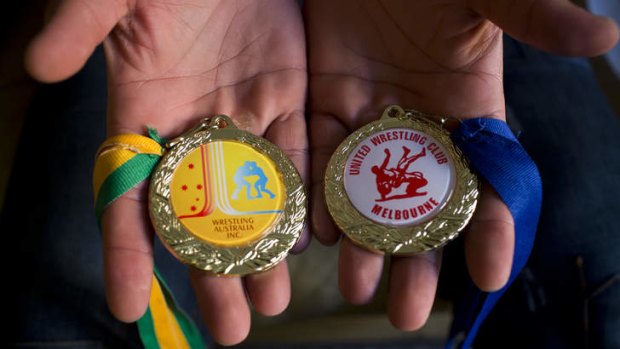 Heavy-weight champ: Two wrestling medals Arzhang has won since arriving in Australia.