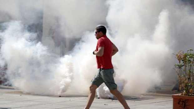An England supporter runs past tear gas in the streets in Marseille, France.