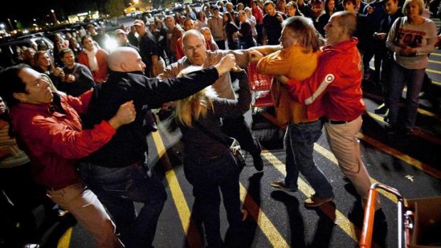 Black Friday ... a crowd gathers as security guards break up a fight between shoppers waiting in line just at a Target.